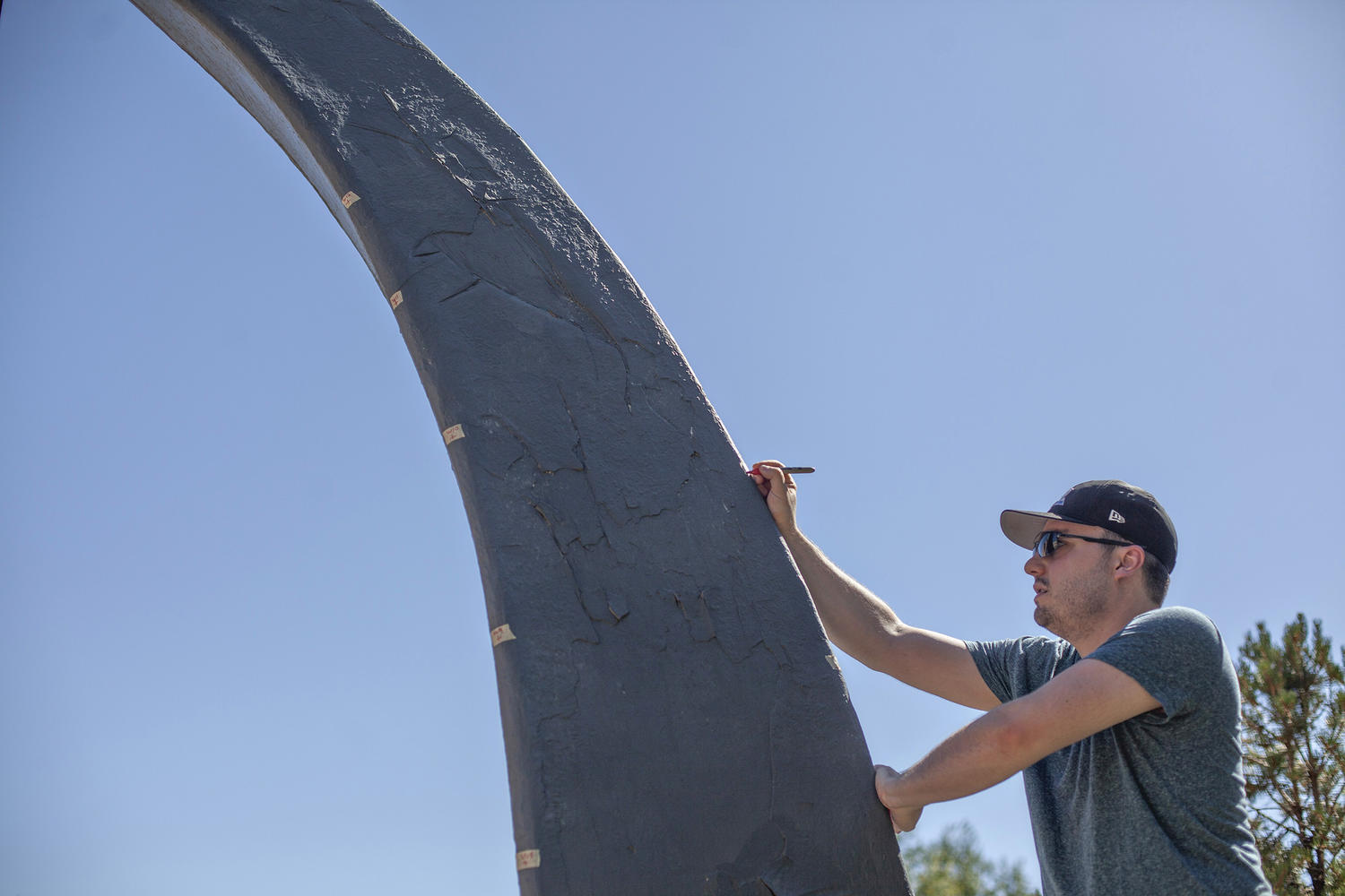 Alumnus Tyler Boschert '07 marks measurements on the sundial.