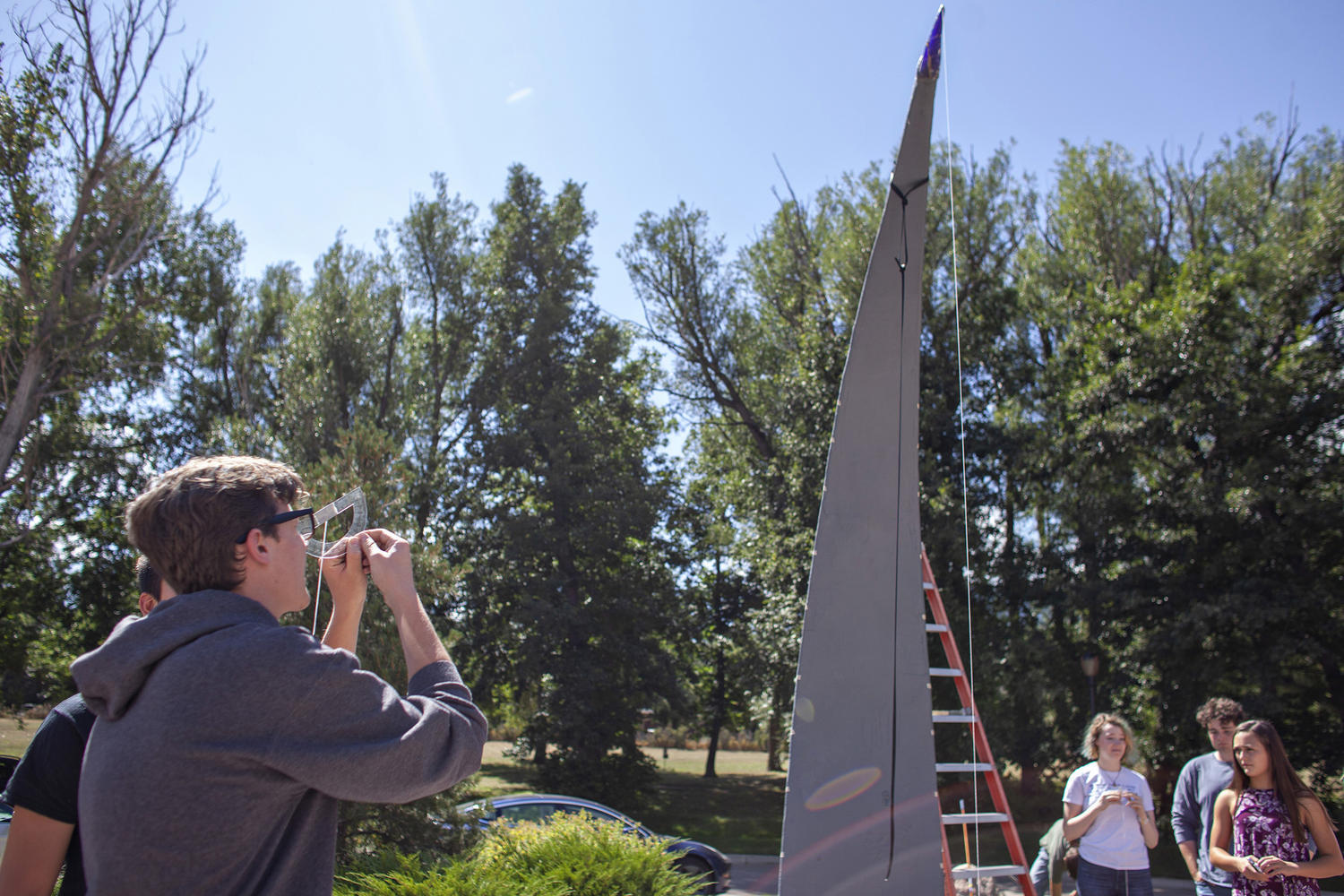 Upper School students measure the height from the ground to the sundial’s gnomon